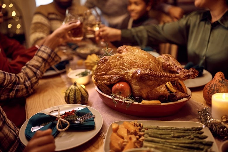 Family toasting around Thanksgiving turkey dinner