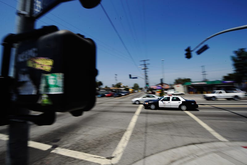 police car speeds through intersection