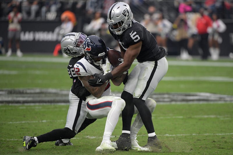 Josh Jacobs #28 and Divine Deablo #5 of the Las Vegas Raiders tackle Nico Collins #12 of the Houston Texans in the third quarter at Allegiant Stadium on October 23, 2022 in Las Vegas, Nevada.
