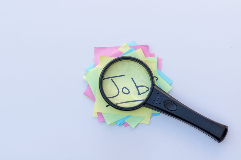 Magnifying glass use as a concept for searching Job handwritten on a sticky note