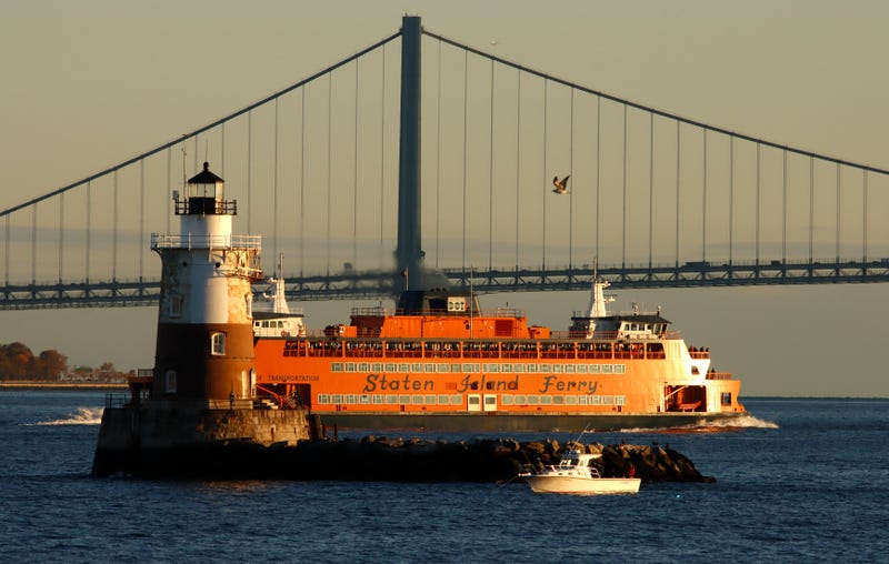 The Staten Island Ferry passes between the Robbins Reef Lighthouse and the Verrazzano-Narrows Bridge in New York City on October 29, 2022, in Bayonne, New Jersey.