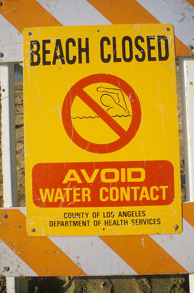 A beach closed warning sign.