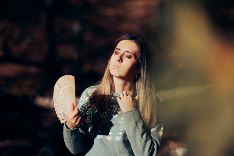 Woman fanning herself. 