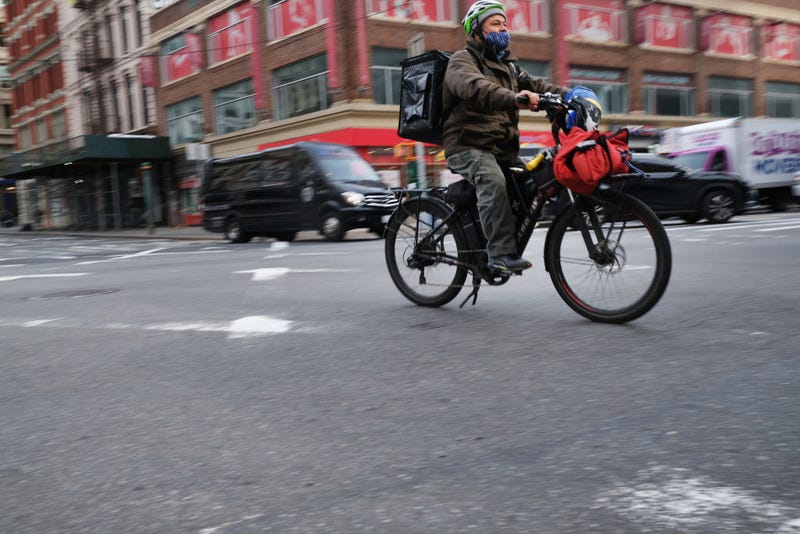 A delivery person rides an electric bicycle through the streets of Manhattan on November 15, 2022, in New York City