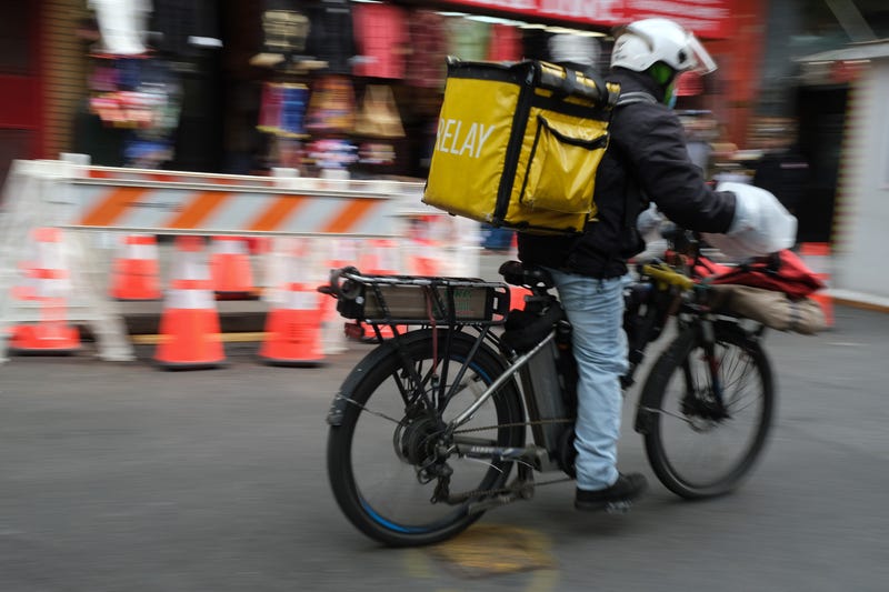 A delivery person rides an electric bicycle through the streets of Manhattan on November 15, 2022 in New York City.