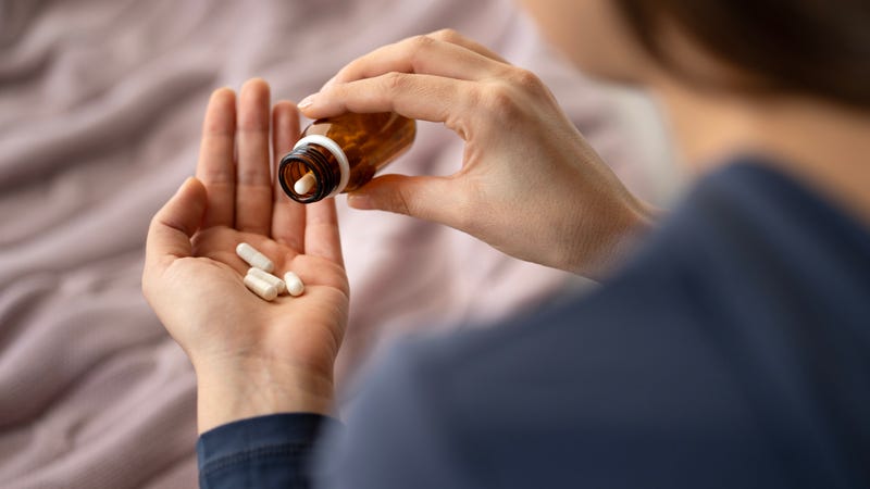 Stock image of young person holding antidepressant pill bottle