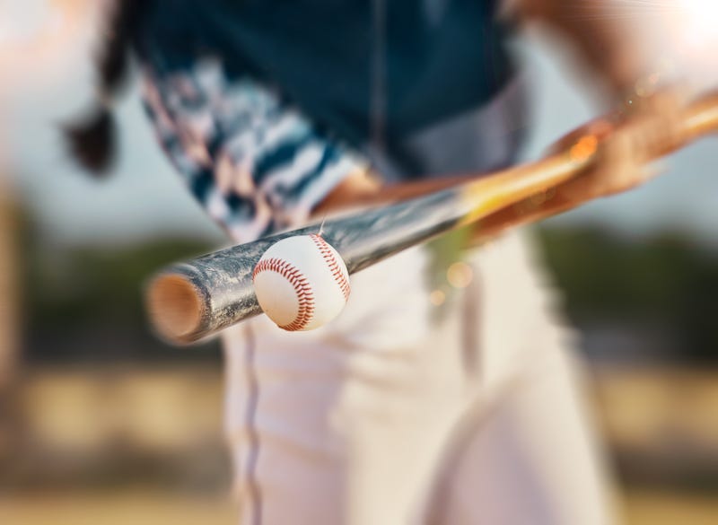 Close-up of teen hitting a baseball 