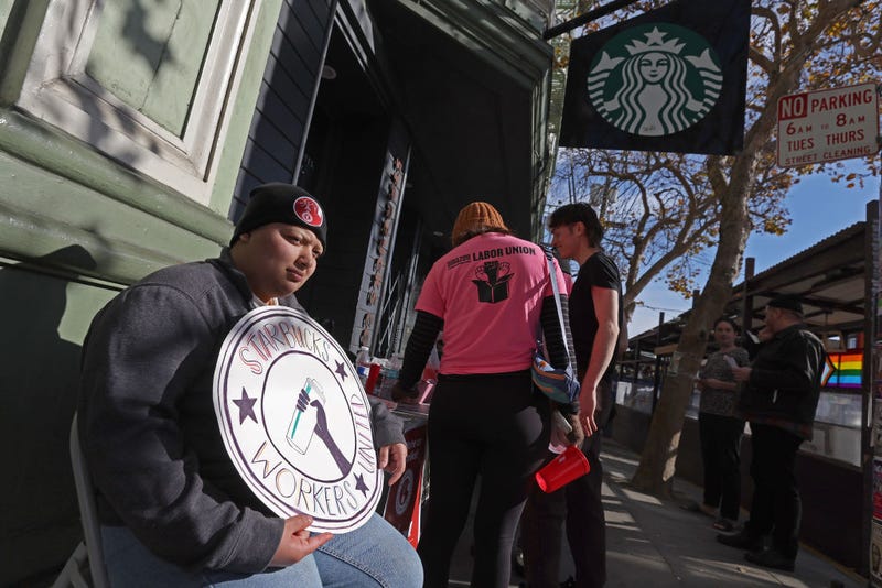 A striking Starbucks worker holds a sign outside of a Starbucks coffee shop during a national strike on November 17, 2022 in San Francisco, California.