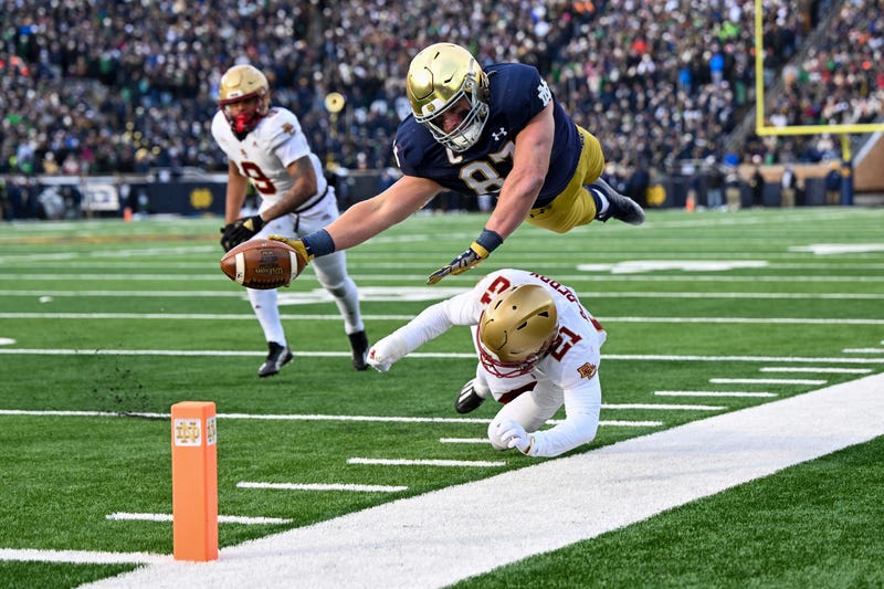 Michael Mayer #87 of the Notre Dame Fighting Irish dives just short of the touchdown in the first half against Josh DeBerry #21 of the Boston College Eagles at Notre Dame Stadium on November 19, 2022