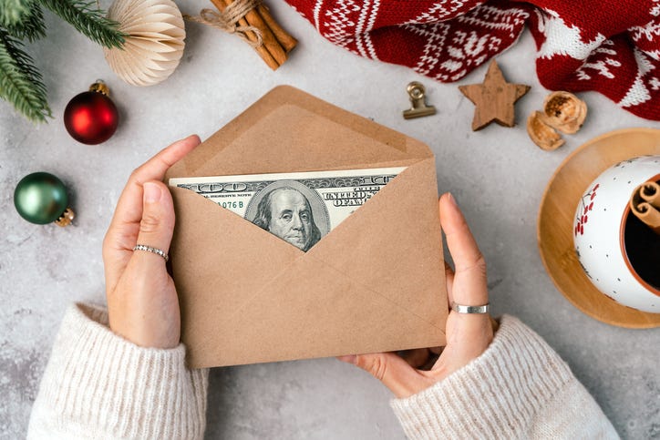 Girl counting US Dollar bills, wrapping in envelop. Top view Girl counting Christmas gifts. Woman hands doing budget, estimating money balance for shopping spree. Female accountant paying taxes.