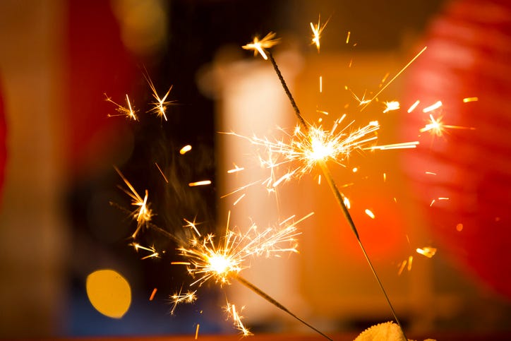 Sparklers burning against a background of blurred decorations