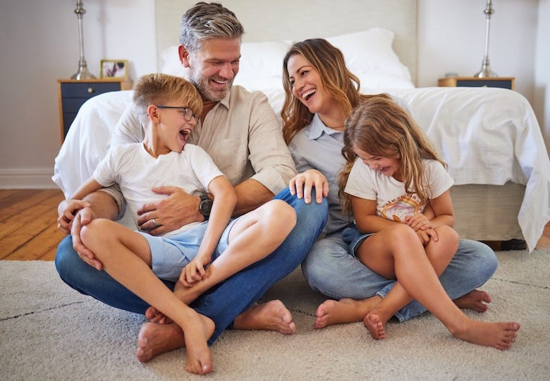 Happy family sitting in a bedroom
