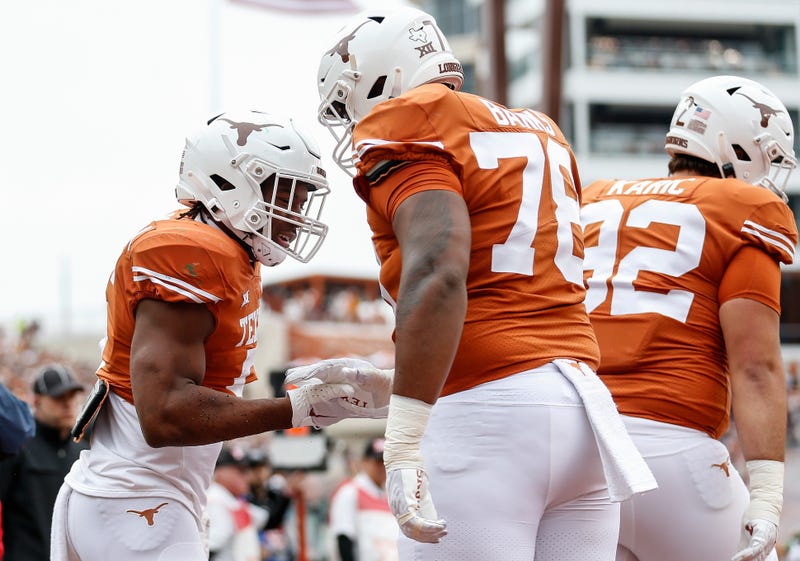 Bijan Robinson #5 of the Texas Longhorns is congratulated by Kelvin Banks Jr. #78 after a touchdown in the first half against the Baylor Bears at Darrell K Royal-Texas Memorial Stadium on Nov. 25, 2022 in Austin, Texas.
