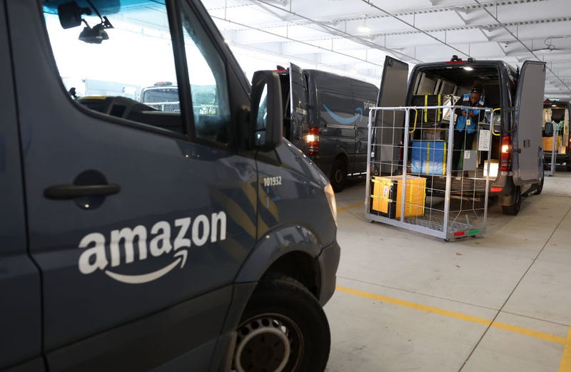 An Amazon driver loads packages into a delivery van at an Amazon delivery station on November 28, 2022 in Alpharetta, Georgia.