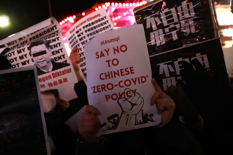 protestor with sign that says 'say no to chinese zero-covid policy'