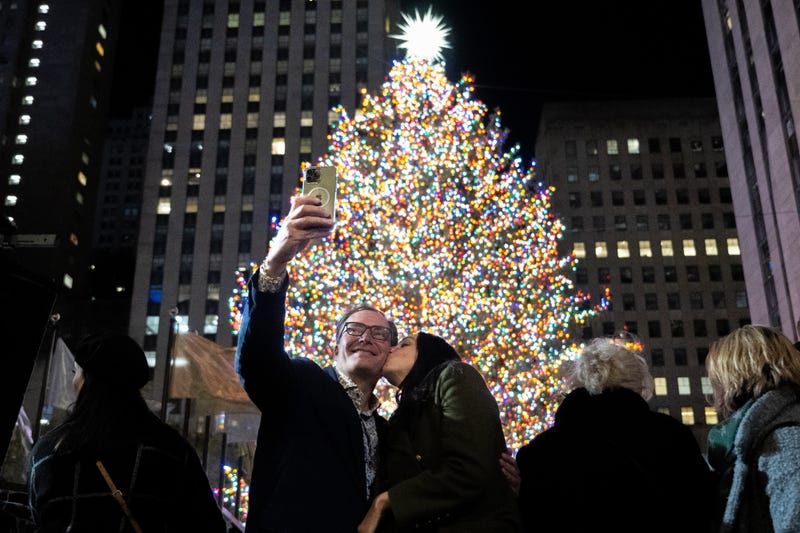 People take photos at the Rockefeller Center Christmas tree during the 90th lighting on Nov. 30, 2022