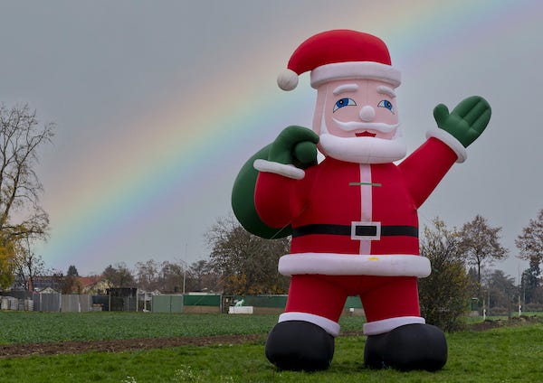 Giant Inflatable Santa Claus in front of the rainbow