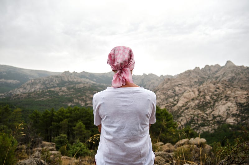 Woman with cancer sitting in a natural space. 