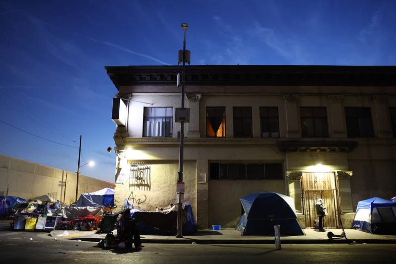 tents outside a dilapidated building at night