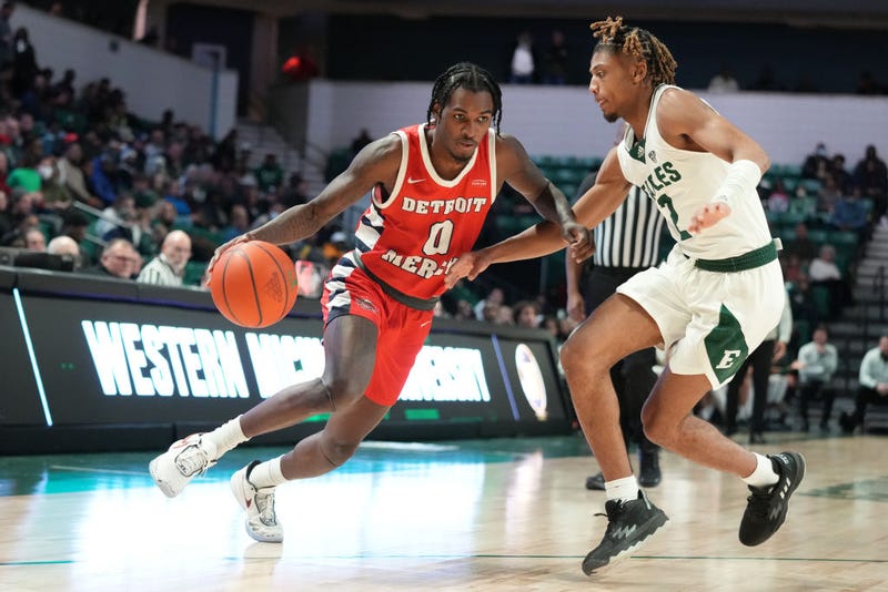 Antoine Davis #0 of the Detroit Mercy Titans dribbles by Noah Farrakhan #2