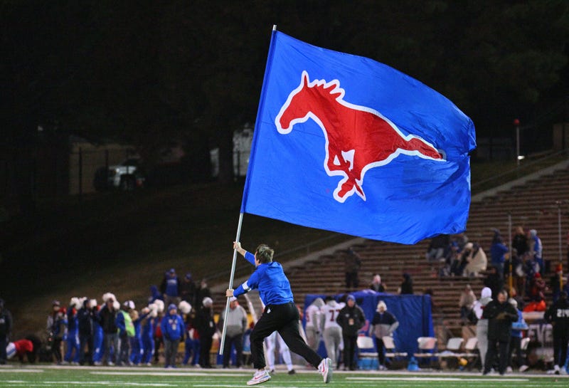 An SMU Mustangs cheerleader carries a flag on the field after the Mustangs scored a touchdown during the second half of the New Mexico Bowl game between the Mustangs and the Brigham Young Cougars at University Stadium on December 17, 2022 in Albuquerque, New Mexico.