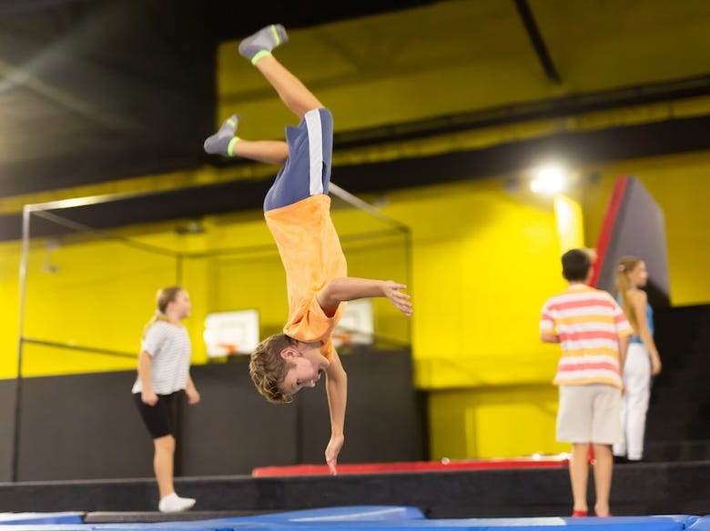 Boy doing a flip on a trampoline at gymnastics