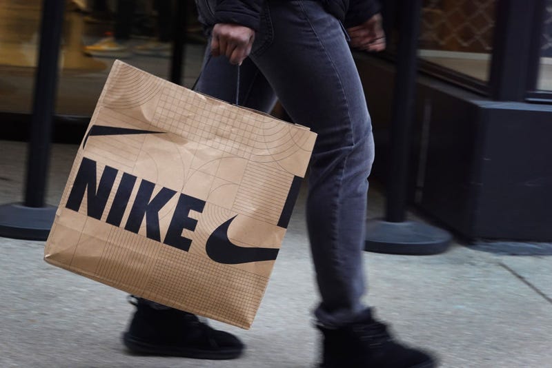 A shopper carries a bag of Nike merchandise along the Magnificent Mile shopping district on December 21, 2022 in Chicago, Illinois. 