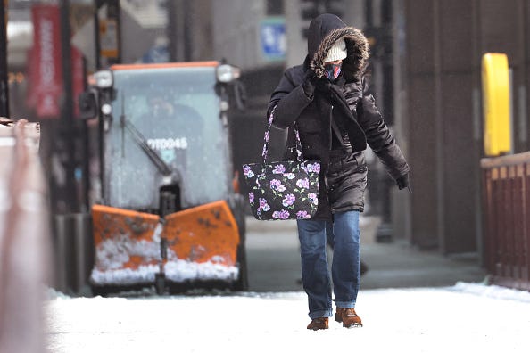 A pedestrian walks through downtown as temperatures hover in the negative single-digits on December 23, 2022 in Chicago, Illinois. Sub-zero temperatures combined with strong winds are expected to grip the city for the next couple of days with wind chill temperature dipping as low as -40 degrees. (Photo by Scott Olson/Getty Images)