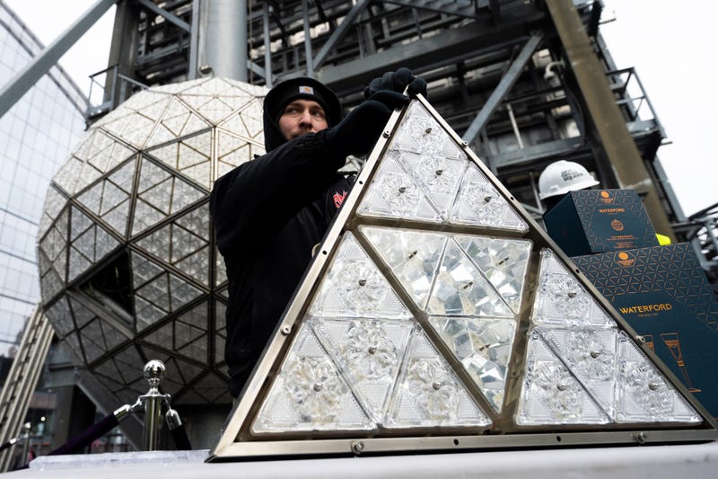 A worker holds up a panel of Waterford Crystal triangles atop One Times Square on Dec. 27, 2022