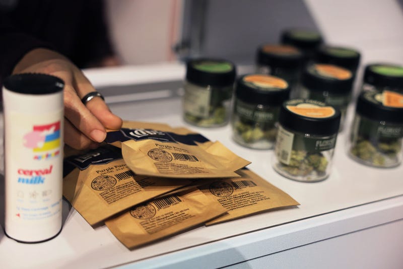 A Housing Works Cannabis Co staff member places marijuana products on a shelf