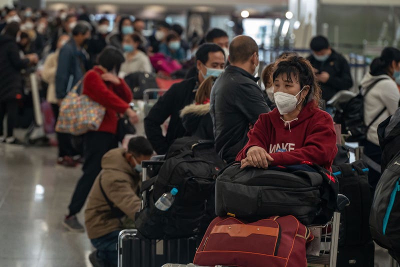 Travelers wait in line to check in at the departure hall of the Hong Kong International Airport on December 30, 2022 in Hong Kong, China.