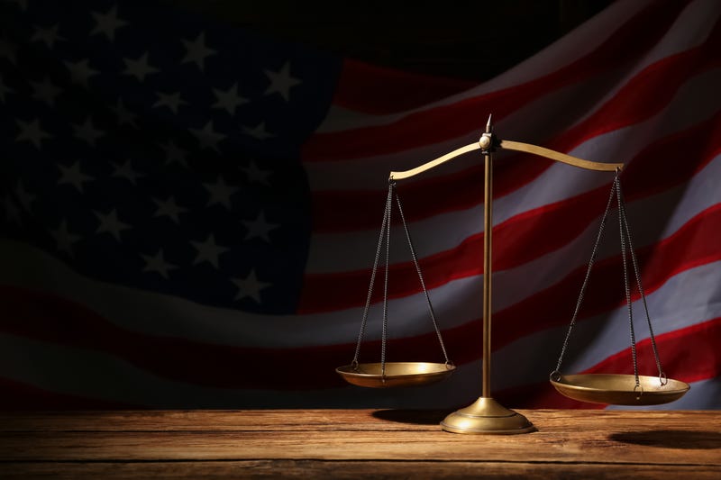 Justice scales and an American flag in the background.