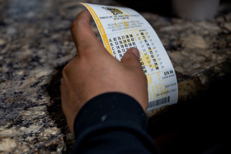 A customer holds his purchased lottery ticket at a CITGO gas station on January 10, 2023 in Austin, Texas. 