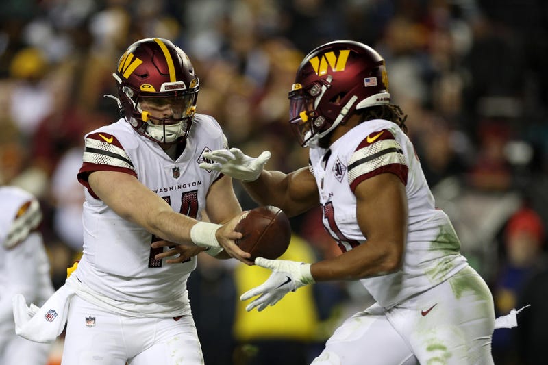 Sam Howell hands the ball off to Jonathan Williams during a Washington Commanders game in 2023.