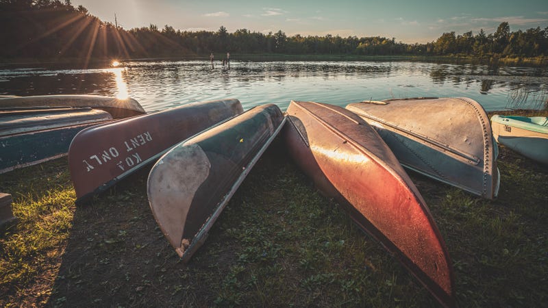 The Canoes for rent at KOA campground with water in background