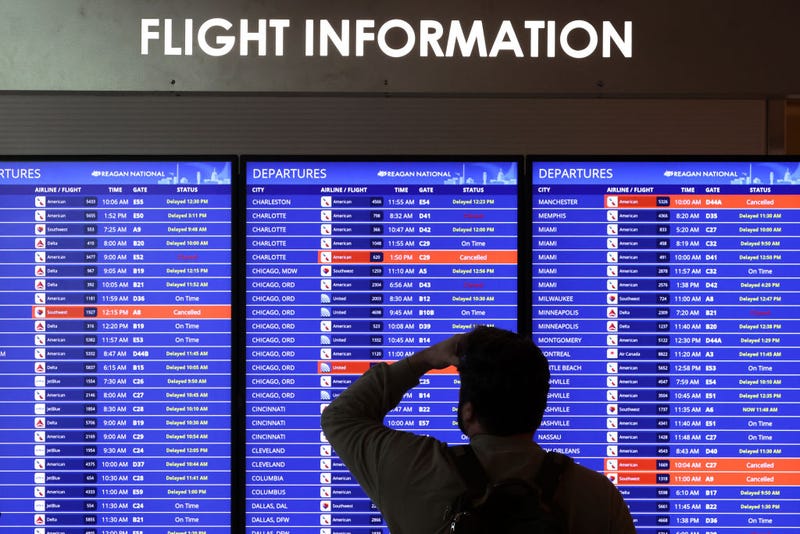 A traveler looks at a flight information board at Ronald Reagan Washington National Airport on January 11, 2023 in Arlington, Virginia. The FAA said it is gradually resuming flights around the country after an outage to the Notice to Air Mission System, a computer system that helps guide air traffic. (Photo by Alex Wong/Getty Images)