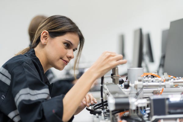 Female engineer training AI robot training kit and mechatronics engineering in the manufacturing automation and robotics academy room