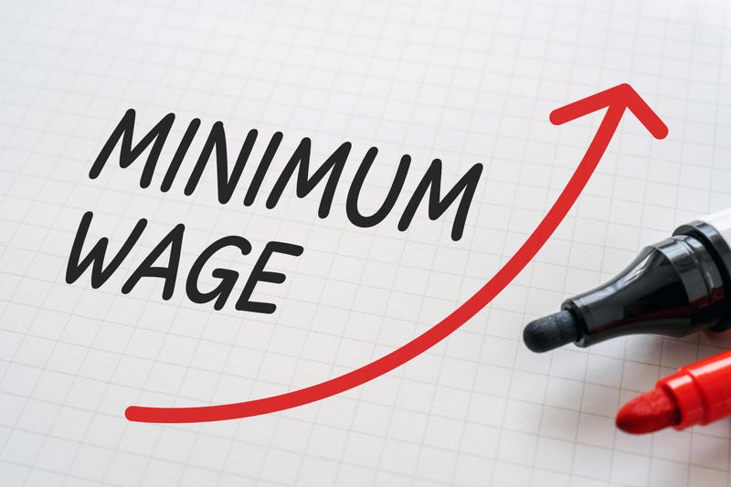 A drawing of a red arrow pointing up to represent an increase and the words around it say, "Minimum Wage"