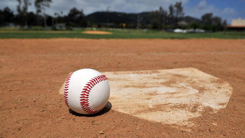 File photo - A baseball near home plate with ballpark in background.