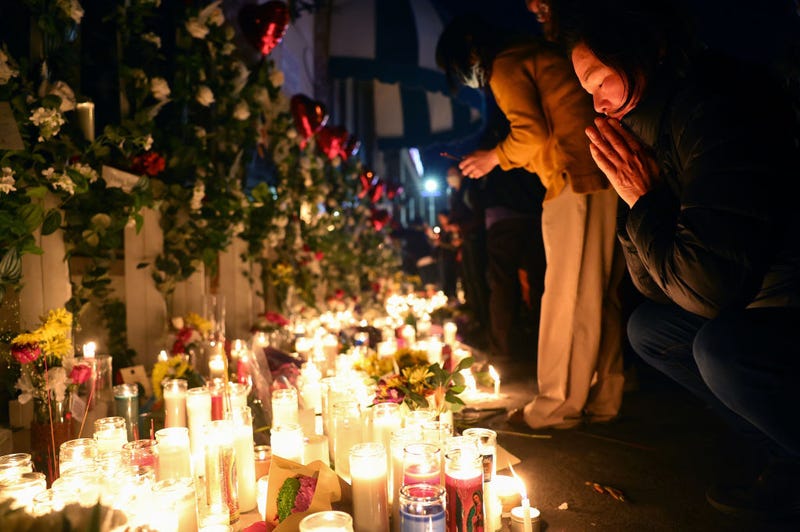 People attend a candlelight vigil at the growing memorial outside the Star Ballroom Dance Studio where a deadly mass shooting took place on January 25, 2023 in Monterey Park, California.