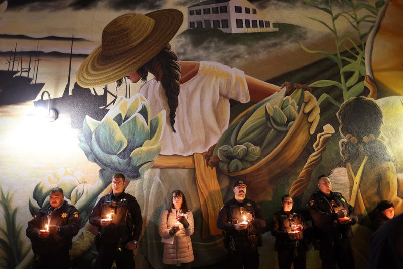 San Mateo County sheriff deputies hold candles during a candlelight vigil for the victims of the recent mass shooting in Half Moon Bay on January 27, 2023 in Half Moon Bay, California.