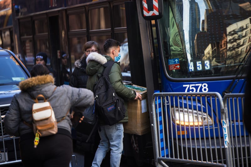 Migrants carry their belongings to a bus after accepting relocation after being evicted from the Watson Hotel on January 30, 2023 in New York City. Migrants who have been staying at the Watson Hotel since arriving to NYC were evicted over the weekend to be relocated to the recently opened up migrant relief center for single adult men at the Brooklyn Cruise Terminal. The ones who refused have been camping out in front of the hotel since eviction. Several migrants who agreed to the relocation returned, complaining of lack of heat and bathroom space.