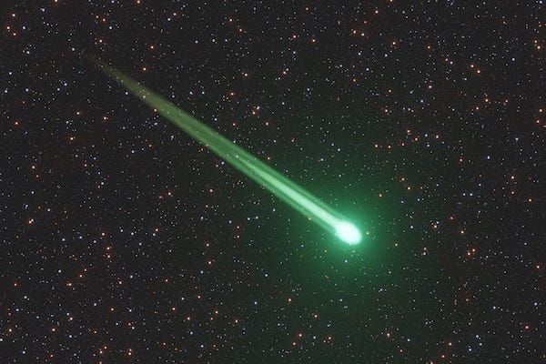 Green meteor or comet flying through the starry sky