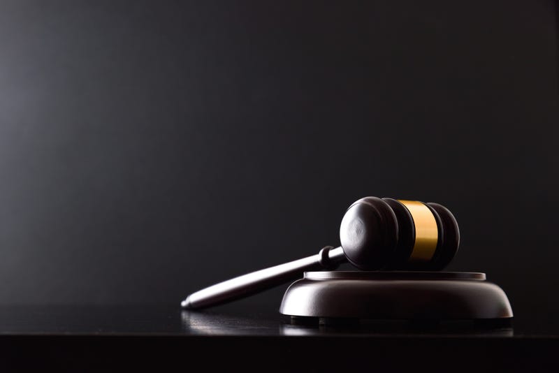 Background of judge's gavel on black table and black isolated background. Front view