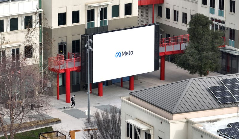 In an aerial view, a worker walks by a large video monitor on the Meta campus on February 02, 2023 in Menlo Park, California. 