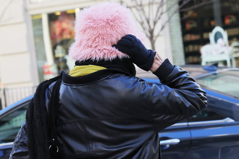 A person holds their hat as they shield themselves from cold winds as the area is seeing record-breaking low temperatures on February 03, 2023 in New York City.