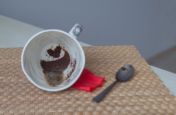 Coffee grounds in the shape of a heart in a mug