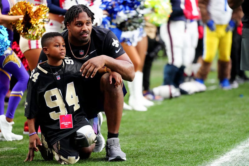 Cam Jordan with child in Saints jersey