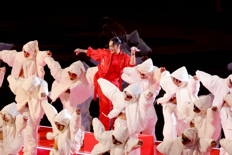 rihanna at the super bowl halftime show. she wears all red and is surrounded by dancers in white