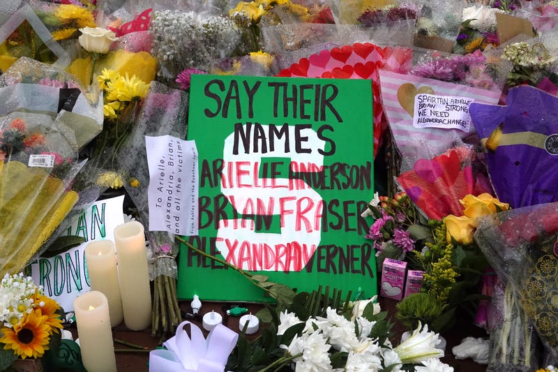 Flowers are laid at the base of the spartan statue on the campus of Michigan State University as a tribute to the students killed 